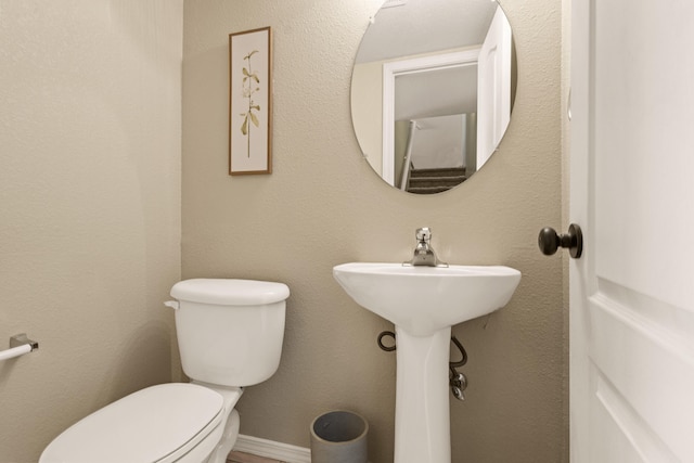 bathroom with toilet and baseboards