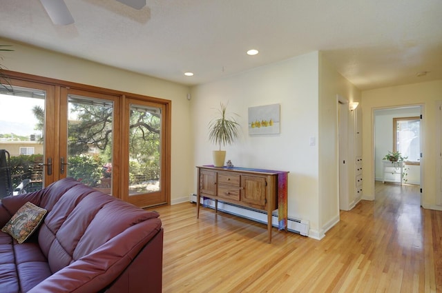 interior space featuring light wood-style flooring, a baseboard heating unit, baseboards, and recessed lighting