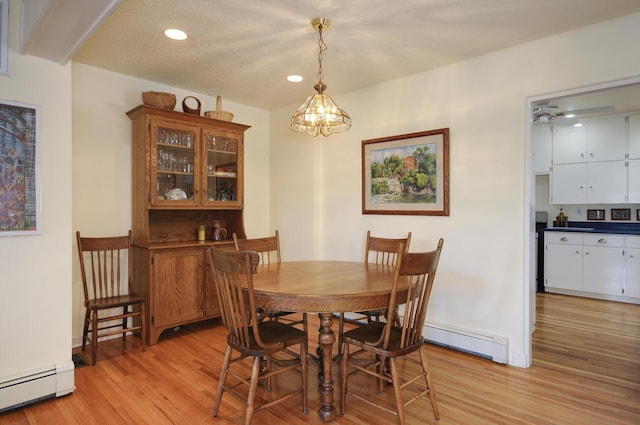 dining room with light wood-style floors, a baseboard radiator, and recessed lighting