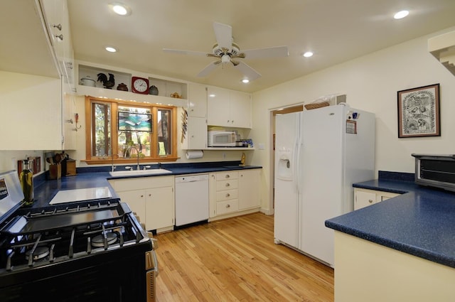 kitchen with light wood-type flooring, white appliances, white cabinets, and a sink