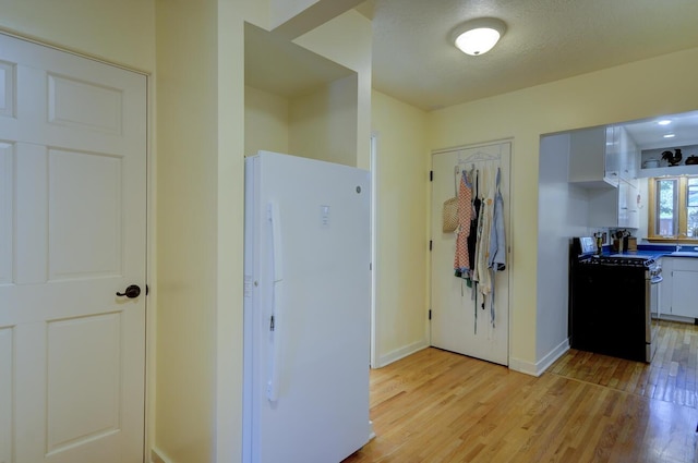 interior space featuring light wood-style flooring and baseboards