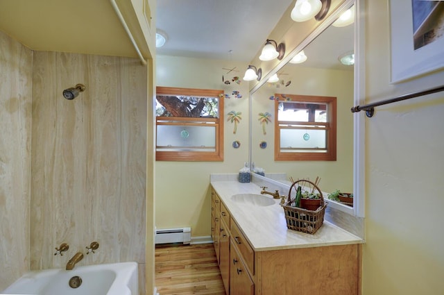 bathroom featuring a baseboard heating unit, plenty of natural light, vanity, and shower / tub combination