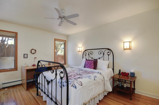 bedroom featuring light wood-style floors, baseboards, ceiling fan, and baseboard heating