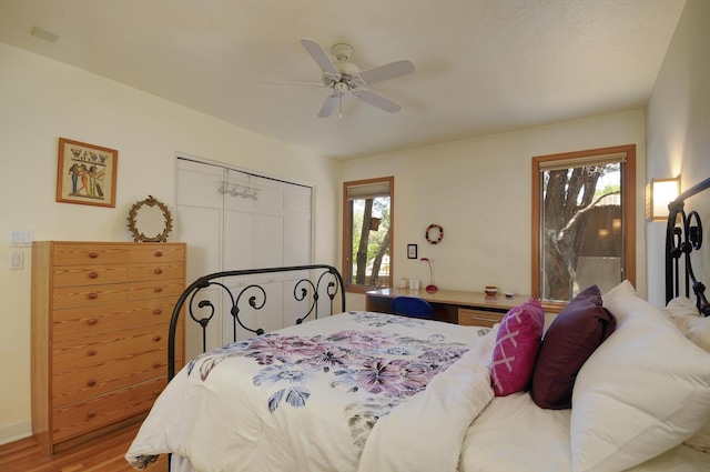 bedroom featuring a ceiling fan, a closet, and wood finished floors