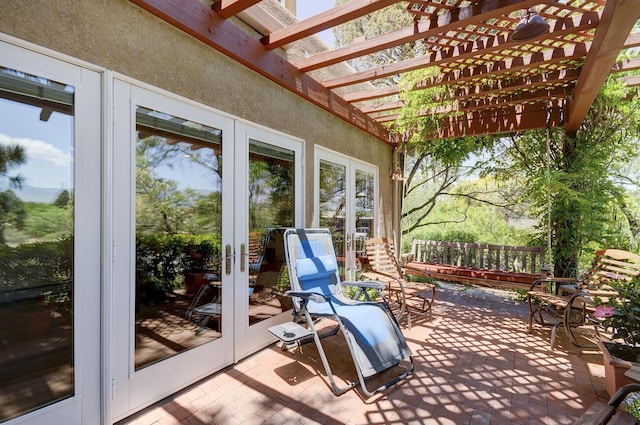 wooden terrace with a patio, a pergola, and french doors