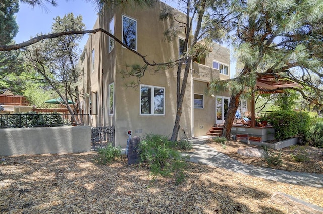 view of home's exterior with fence and stucco siding