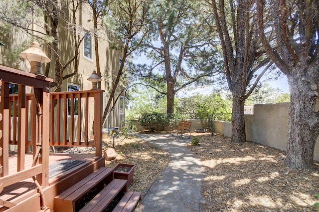 view of yard with a trampoline, fence private yard, and a wooden deck