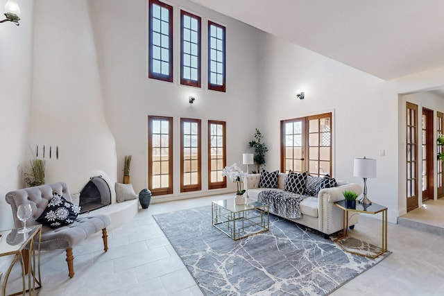 tiled living area featuring french doors and a high ceiling