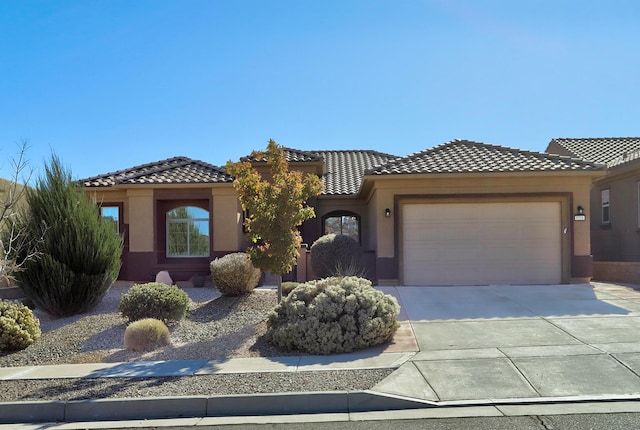 9316 Iron Creek Ln NW, Albuquerque, NM 87120 - mediterranean / spanish home with a garage, driveway, stucco siding, and a tiled roof
