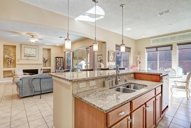9316 Iron Creek Ln NW, Albuquerque, NM 87120 - kitchen with light tile patterned floors, a textured ceiling, a center island with sink, open floor plan, and decorative light fixtures