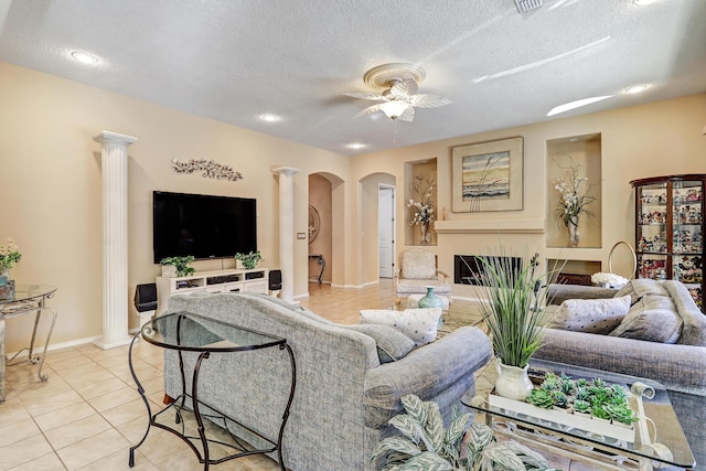 9316 Iron Creek Ln NW, Albuquerque, NM 87120 - living room featuring decorative columns, ceiling fan, a textured ceiling, arched walkways, and light tile patterned flooring