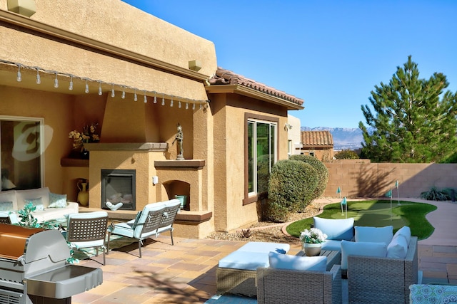 9316 Iron Creek Ln NW, Albuquerque, NM 87120 - view of patio / terrace with an outdoor living space with a fireplace and a putting green