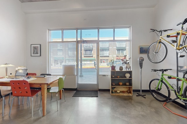 interior space featuring baseboards, plenty of natural light, and finished concrete floors