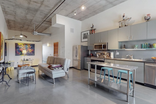 kitchen featuring visible vents, backsplash, gray cabinets, appliances with stainless steel finishes, and a high ceiling