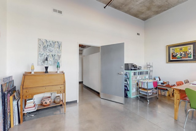 interior space featuring visible vents, concrete floors, and baseboards