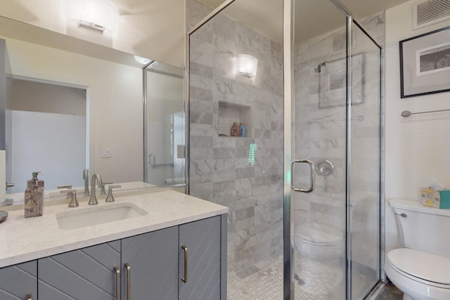 full bath featuring a stall shower, toilet, and vanity