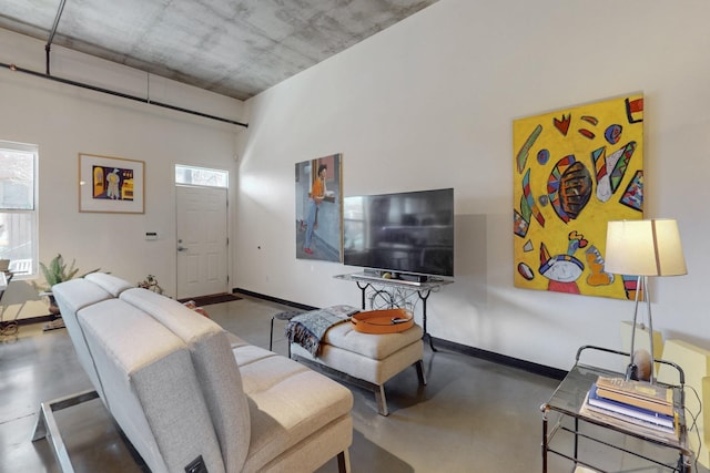 living room featuring finished concrete flooring and baseboards