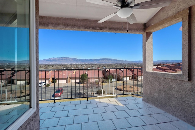 view of patio with a mountain view, ceiling fan, and a balcony