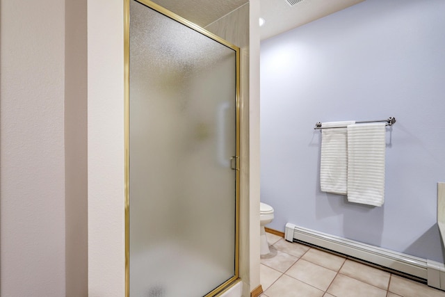 full bathroom featuring a shower stall, a baseboard radiator, toilet, and tile patterned floors