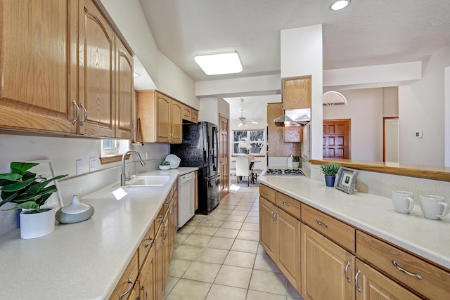 kitchen featuring light countertops, white dishwasher, under cabinet range hood, and a sink