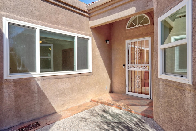 entrance to property featuring stucco siding