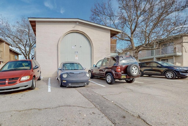 exterior space featuring brick siding and uncovered parking