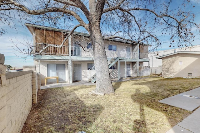 back of house with stairway, a patio, fence, and stucco siding