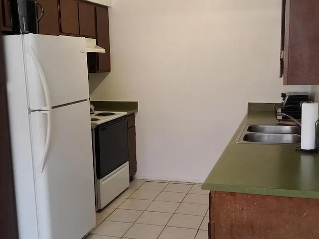 kitchen with light tile patterned floors, freestanding refrigerator, a sink, range with electric cooktop, and under cabinet range hood