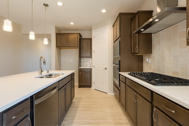 2178 Janet Way, Rio Rancho, NM 87144 - kitchen with appliances with stainless steel finishes, wall chimney exhaust hood, a sink, light countertops, and pendant lighting