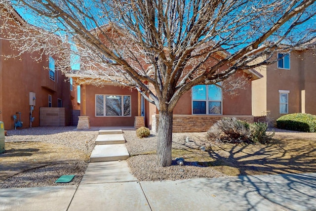 view of front of property featuring stone siding and stucco siding