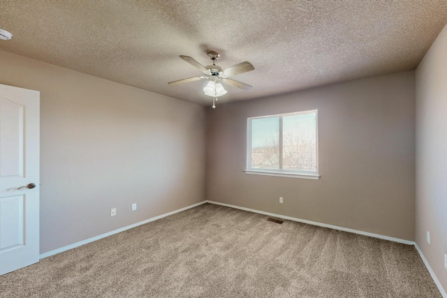 spare room with ceiling fan, carpet, visible vents, and baseboards