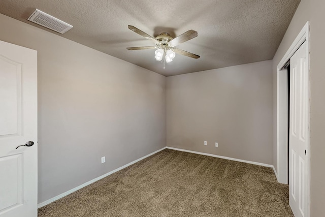 unfurnished bedroom with baseboards, visible vents, a textured ceiling, and carpet flooring