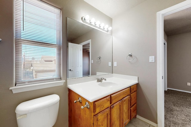 bathroom featuring toilet, baseboards, and vanity