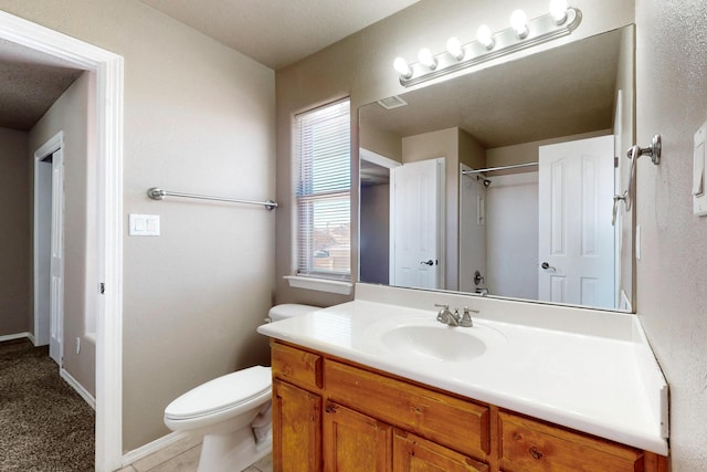 bathroom featuring vanity, toilet, and baseboards