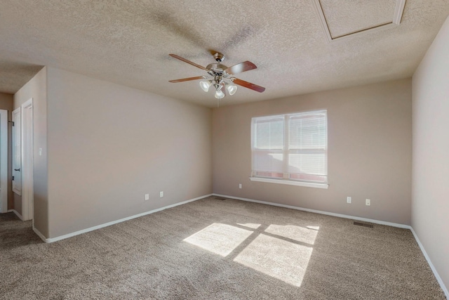 carpeted empty room featuring baseboards, a textured ceiling, visible vents, and a ceiling fan