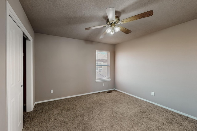 spare room featuring carpet, visible vents, ceiling fan, and baseboards