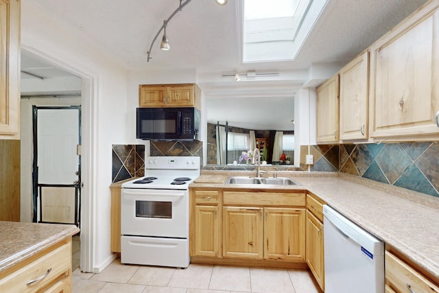 kitchen featuring white appliances, light brown cabinets, and a sink