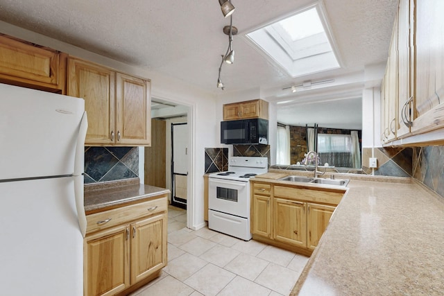 kitchen with light tile patterned floors, white appliances, a skylight, a sink, and backsplash