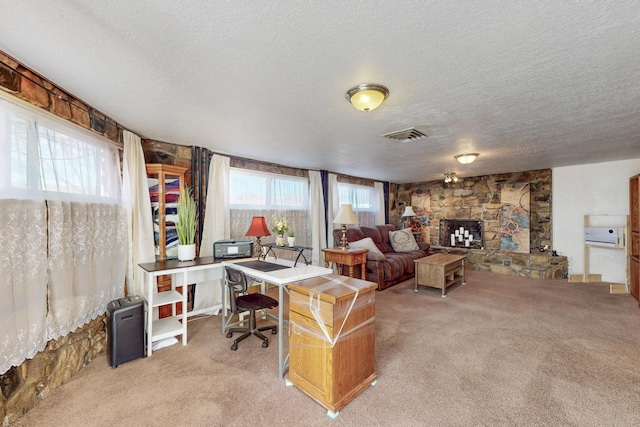 office area featuring a textured ceiling, carpet floors, and a fireplace