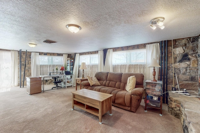 carpeted living area with visible vents and a textured ceiling