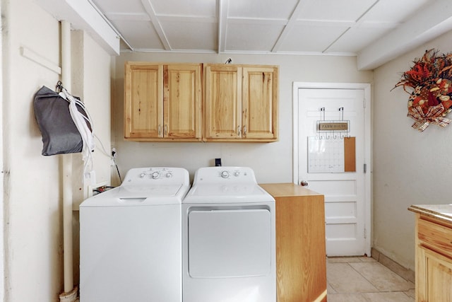 laundry room with light tile patterned floors, washing machine and dryer, and cabinet space