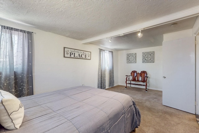 carpeted bedroom with track lighting, baseboards, and a textured ceiling