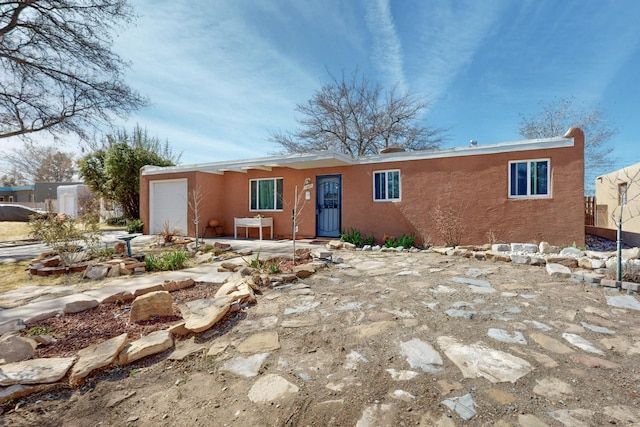 ranch-style house featuring an attached garage and stucco siding