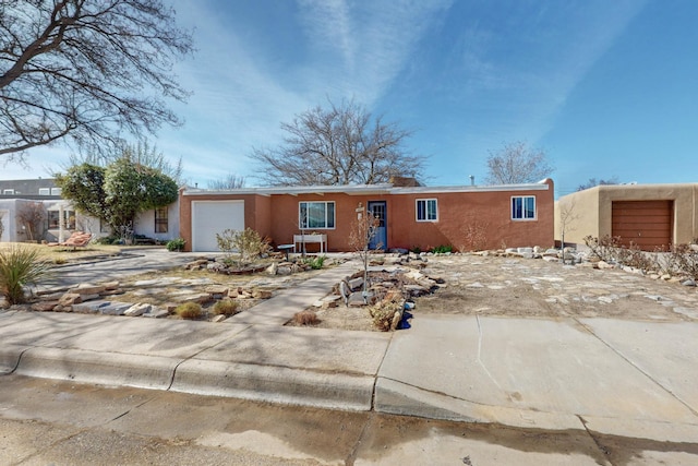 view of front of house featuring a garage, concrete driveway, and stucco siding