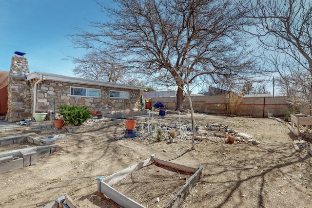 view of yard with fence and a vegetable garden