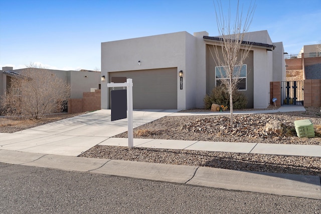 view of front of property with driveway, an attached garage, a gate, and stucco siding