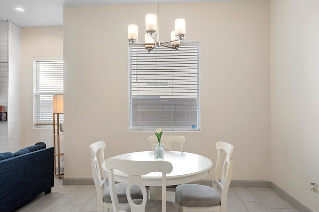 dining area with an inviting chandelier and baseboards