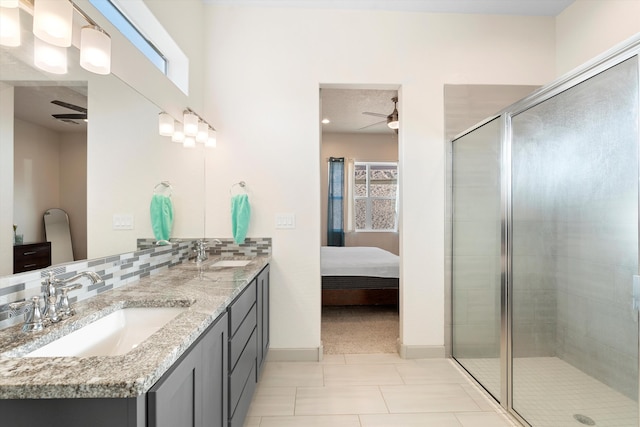 ensuite bathroom with ceiling fan, a sink, and a shower stall