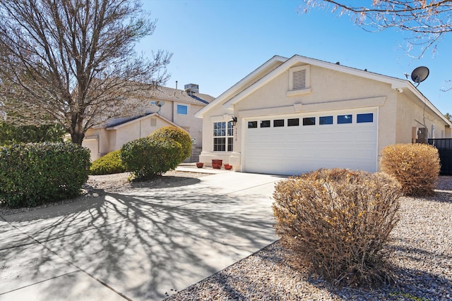 single story home with a garage, concrete driveway, and stucco siding