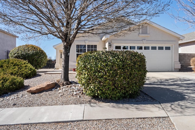 view of front of house featuring a garage, driveway, and stucco siding